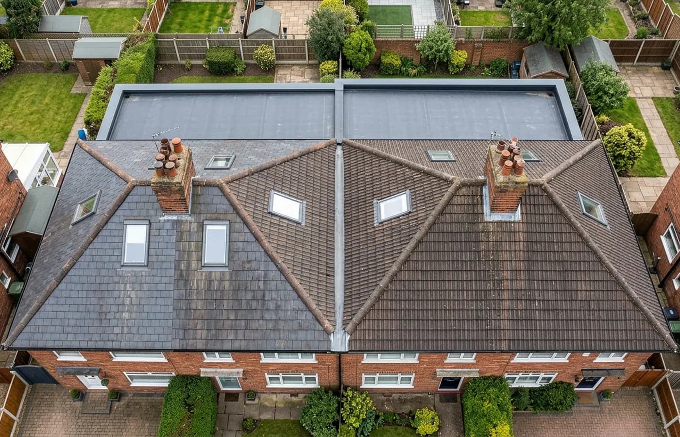 A pair of houses photographed from directly above showing the full roof plan, two chimney stacks with pots, rooflights, the lead lined valley between the hips and a large flat roofed rear extension